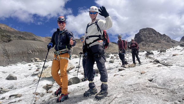 Die Gruppe bei strahlendem Sonnenschein beim Abstieg über ein Eisfeld mit entsprechender Ausrüstung.