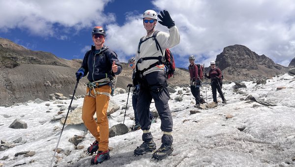 Die Gruppe bei strahlendem Sonnenschein beim Abstieg über ein Eisfeld mit entsprechender Ausrüstung.