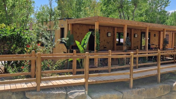 Blick auf die Mobilhomes aus Holz im Hintergrund sieht man Bäume