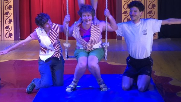 Vier Zirkusartisten machen ein Kunststück mit dem Trapez.