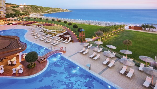 Umgeben von hübsch dekorierten Pflanzen der hoteleigene Pool mit Sonnenliegen