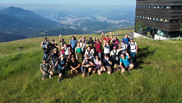Die Gruppe posiert auf einer Wiese hoch über dem Tal.