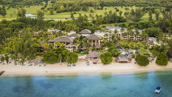 Ein Sandstrand mit Meer und im Hintergrund markante Hügel