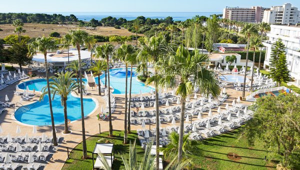 Der grosse hoteleigene Pool mit Sonnenliegen und Palmen