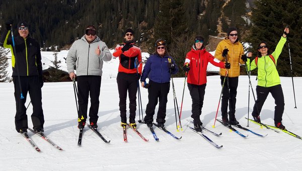 Eine Gruppe Skifahrer*innen posiert und lächelt für ein Foto.