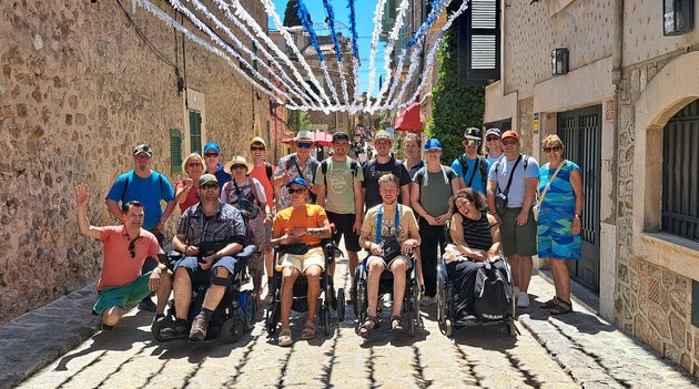 Eine Gruppe von Menschen posiert inmitten auf einer Strasse in einer Nebengasse.